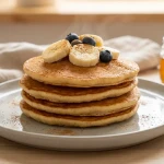 Pancakes aux bananes et myrtilles avec miel.